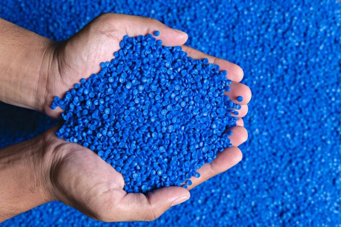 hands cupping plastic pellets